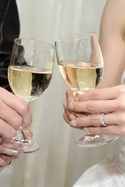 对幸福的夫妇喝葡萄酒和碰杯聚焦背景的人两个眼镜和两只手的特写