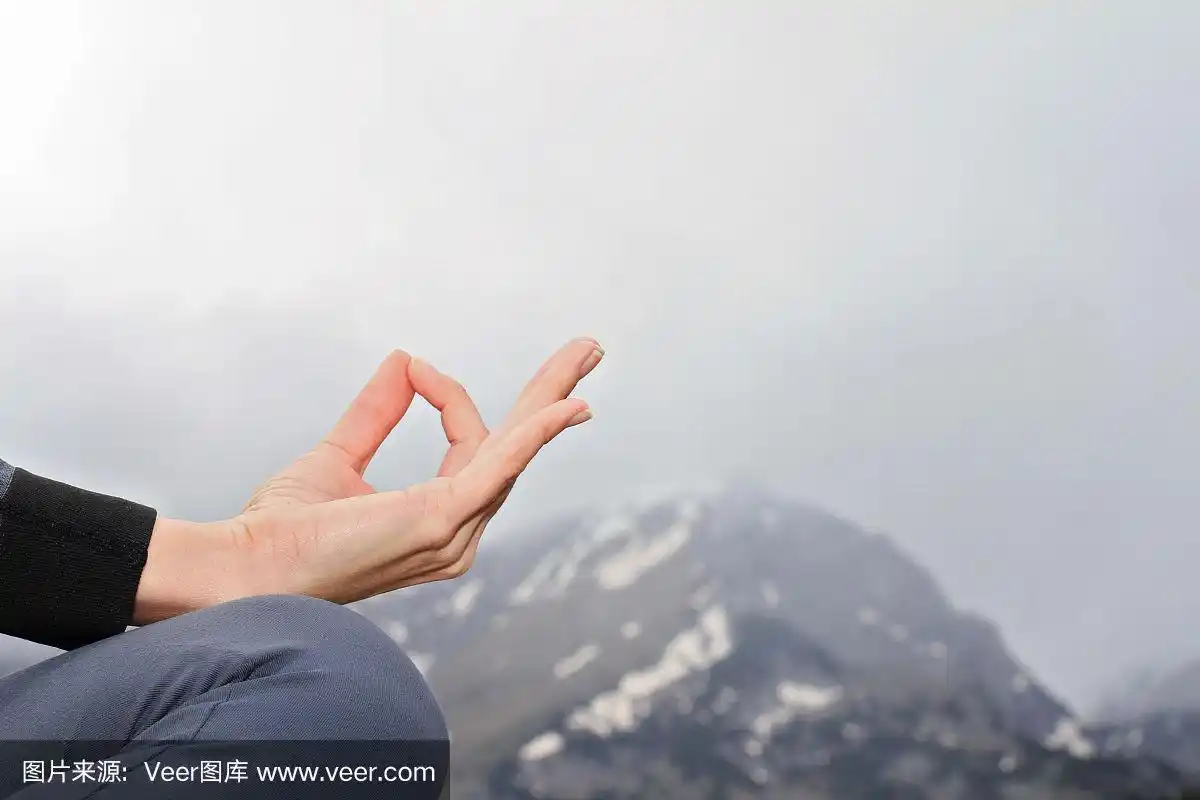 瑜伽女子在山峰上冥想,双手合十