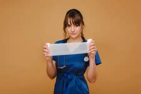 伤害身穿白大褂,戴口罩的女医护人员拿着一条扭曲的纱布绷带包扎伤口