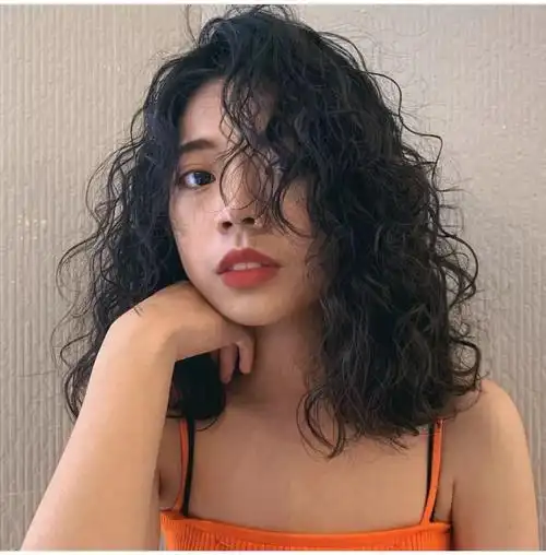 女生一头羊毛卷发型加上短短的狗啃刘海,显得很是