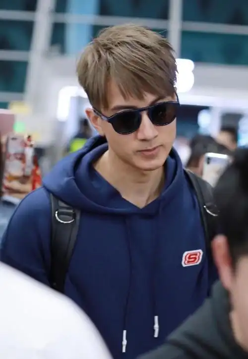 型男奶爸吴尊穿深蓝色连帽卫衣搭配运动裤现身机场 发色潮范帅气