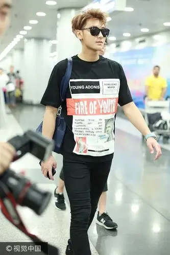 黄子韬前往巴黎男装周全黑look现身机场 手机玩不停全程冷漠脸