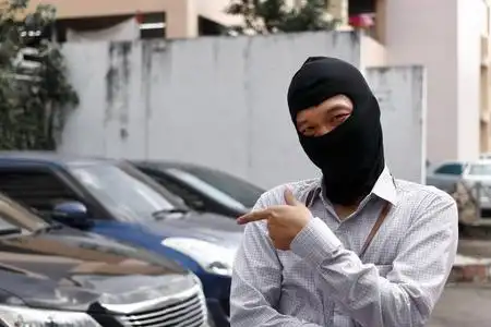 蒙面黑衣小偷试图闯入汽车照片