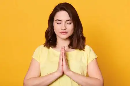 人们生活方式的概念.女性双手合十祈祷,闭着眼睛站着.照片