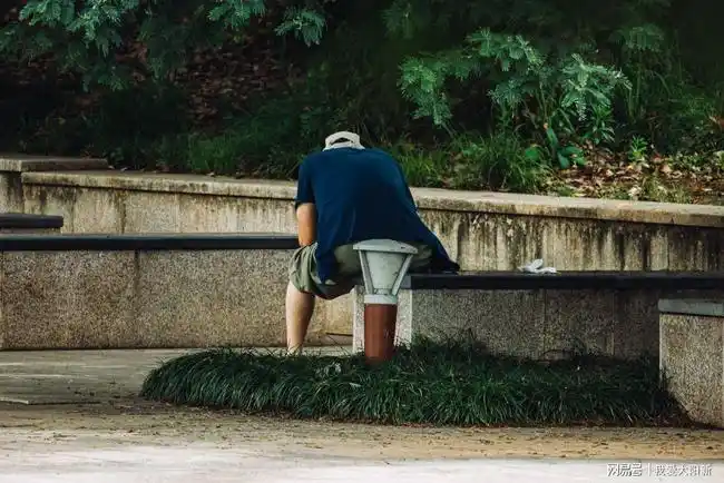 孤独的背影.孤单的大叔,似乎是在刷手机消磨时间!