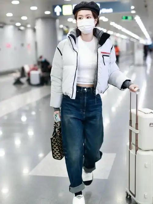 乔欣机场私服look,身穿短款羽绒夹克内搭短款针织衫,全身prada 的酷