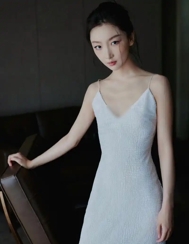 周冬雨一袭白色吊带礼服亮相,作为代言人出席活动神采奕奕,侧脸下颌线