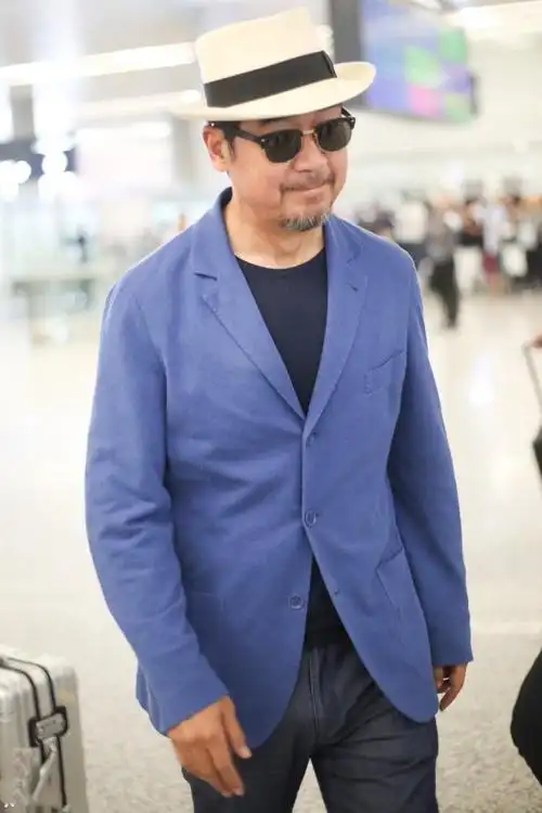 2018年5月23日,大明星张国立现身上海机场.蓝色西服,黑眼镜,礼帽.