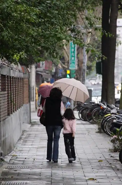 小女孩和母亲带着雨伞的背影图片