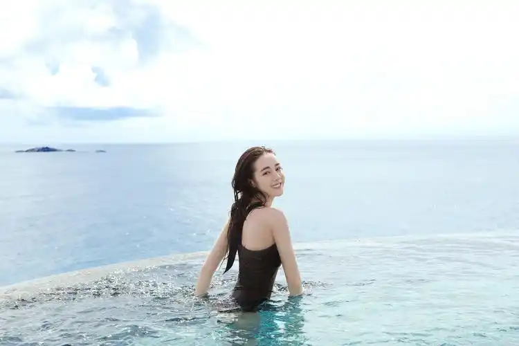 照片中,迪丽热巴比基尼装水中畅游全身湿漉漉,回眸一笑模样清纯可人