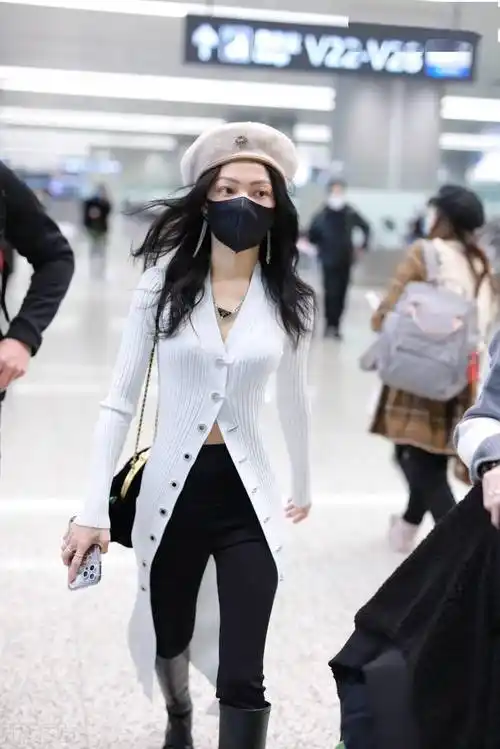 街拍:张韶涵一袭白色针织开衫衣搭长靴走路带风潇洒随性_机场_上海