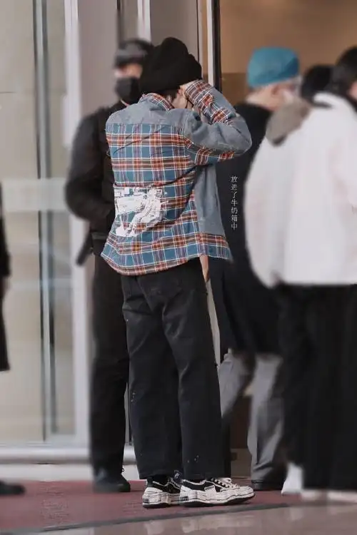 严浩翔今日机场私服分享,牛仔拼接格纹衬衫搭配细微墨点设计牛仔裤