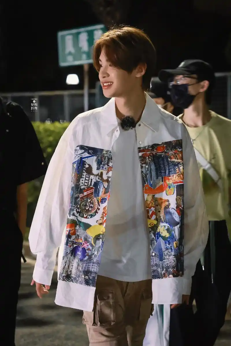 黄明昊《一起露营吧》最新拍摄路透造型,身穿白色背心搭配印花衬衫和