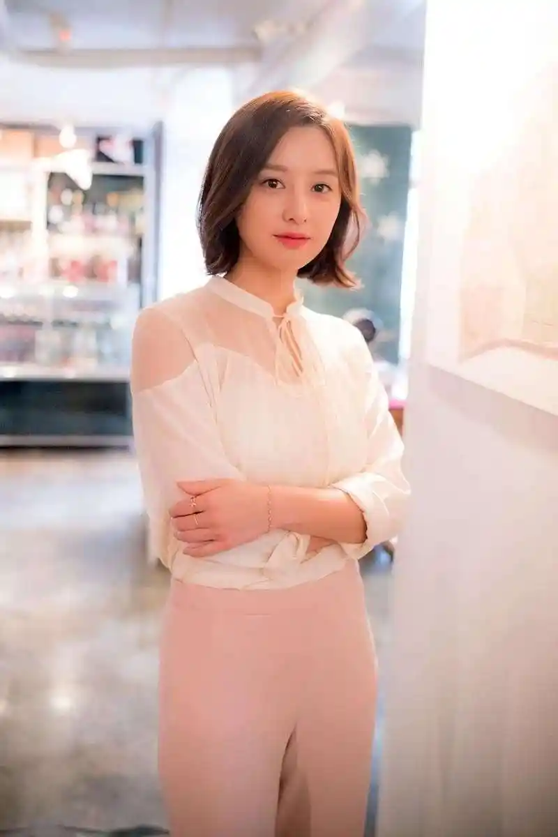 这张照片中的金智媛是一头利落的短发,戴着精致的耳饰,上身选择一个