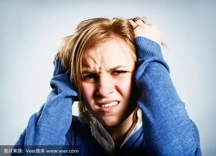 不幸的年轻金发女人痛苦地抓着头
