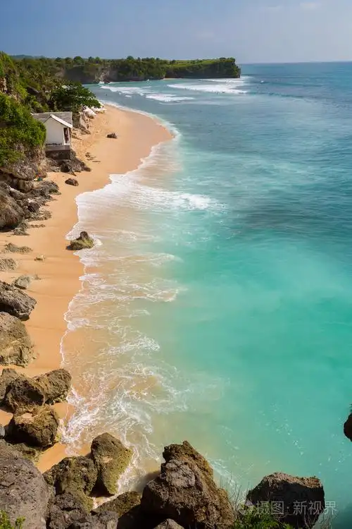 美丽的海滩在那里人们正在冲浪在水中的视图巴厘岛balangan