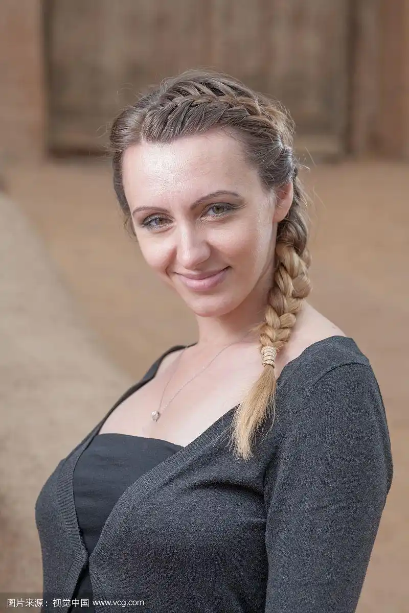 编辫子的俄罗斯妇女年轻的一个辫子-肖像的漂亮的棕色头发的妇女