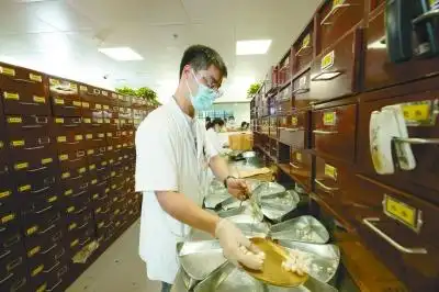 药房里的中药师快而准地为患者抓药.