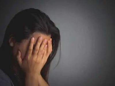 伤心女人独自坐在一个空房间照片