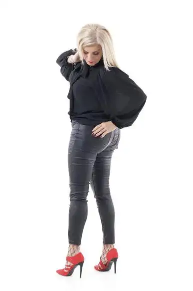 背影迷人的中年金发女人在魅力的衣服转身和向后看图片