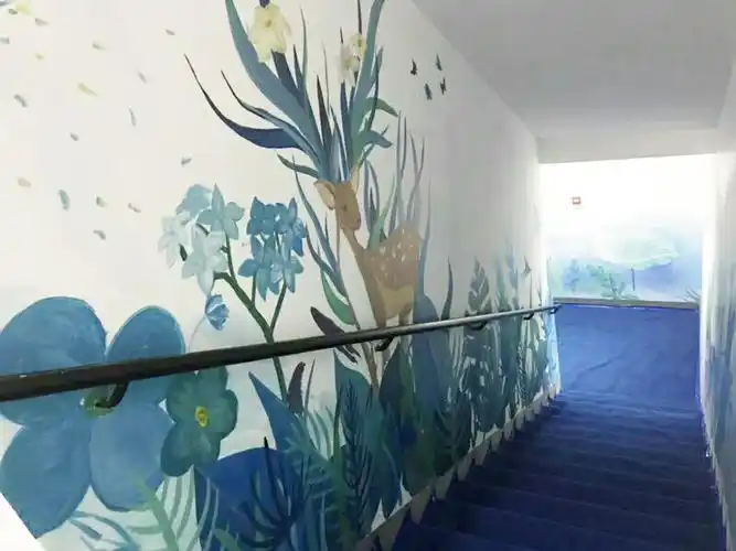 慢慢就已经被改造美化了,楼梯墙面的装饰主要是以墙画为主,就是在墙上