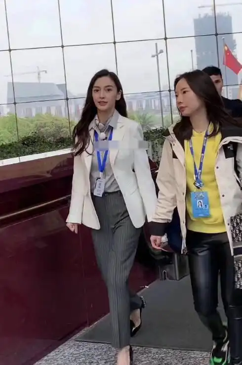 照片中的baby穿着一套职业装,胸前挂着一张工作牌,披着头发,一出现在