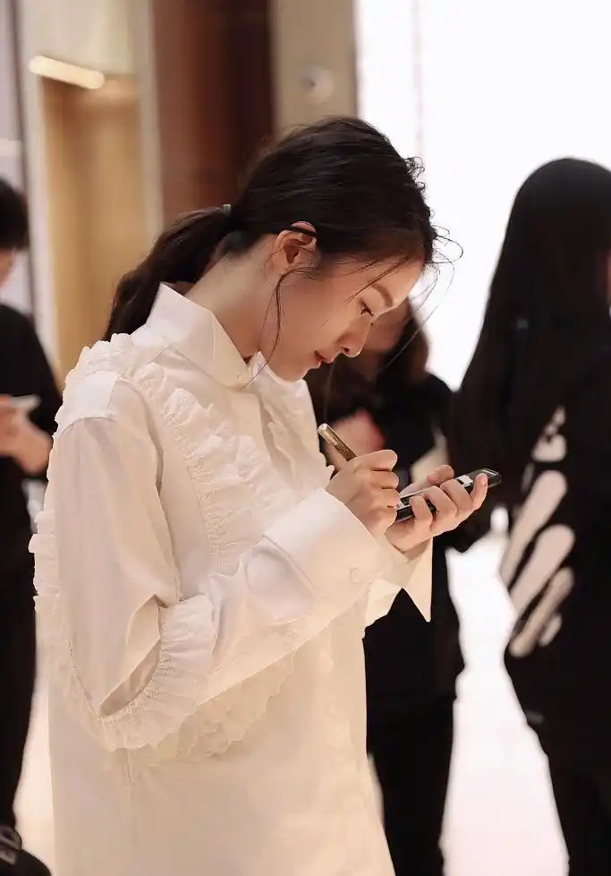 张雪迎穿白衬衫笑容甜美气质清纯 低头玩手机侧颜精致