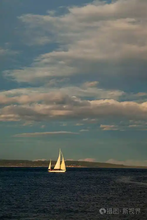 华盛顿汤森港附近日落时水面上的一艘小帆船