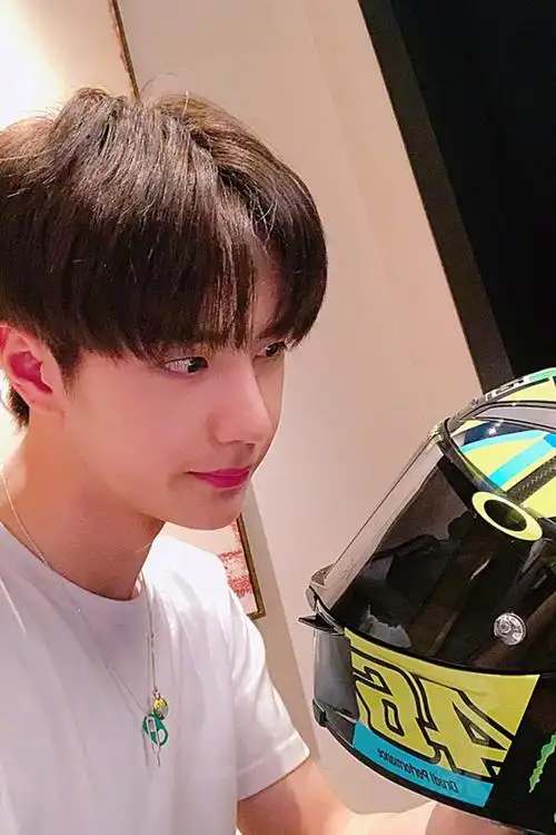 王一博正拿着一个头盔,和头盔在瞪眼,很有童心.