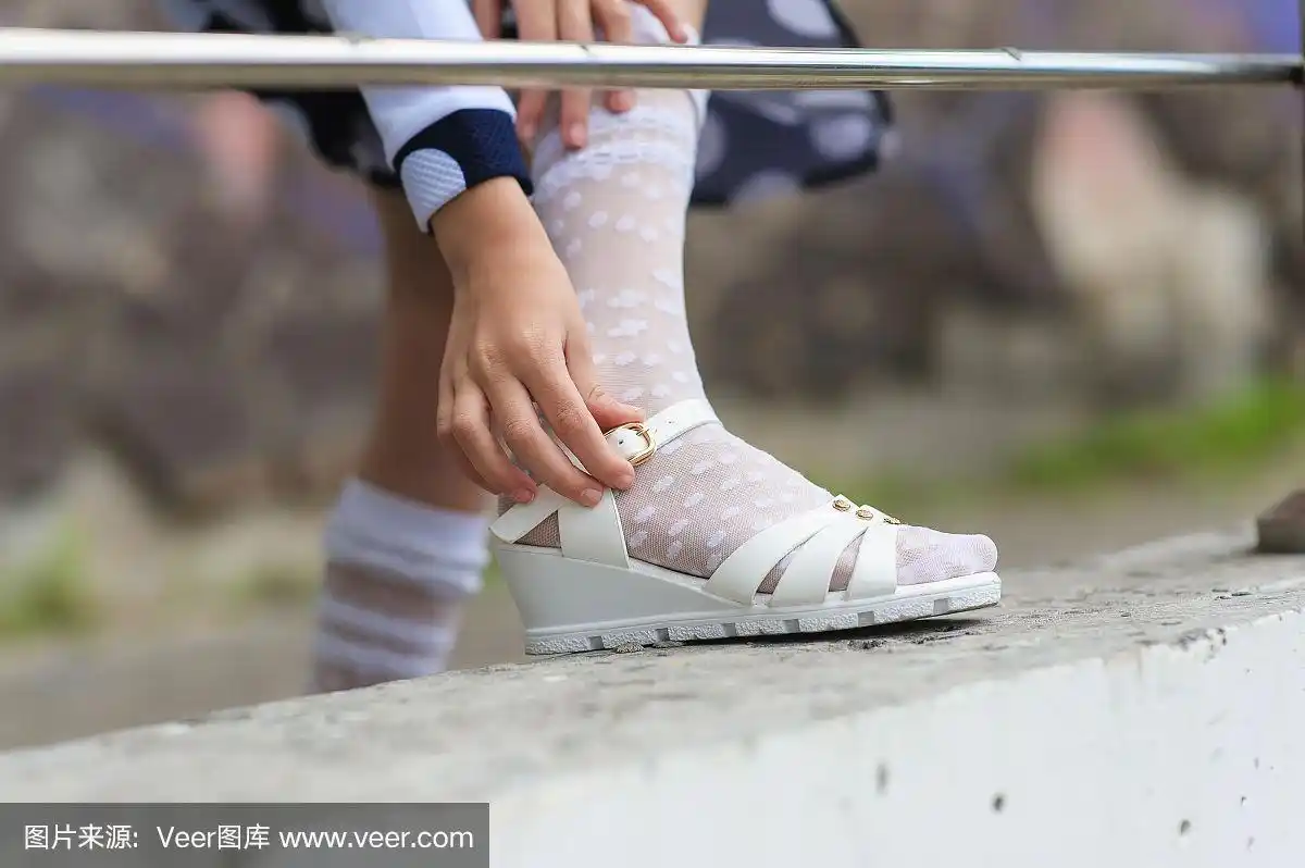 小女孩正在穿凉鞋