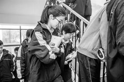 图片说明:下课铃声一响,建平中学新高一学生们背着书包,拿着书寻找