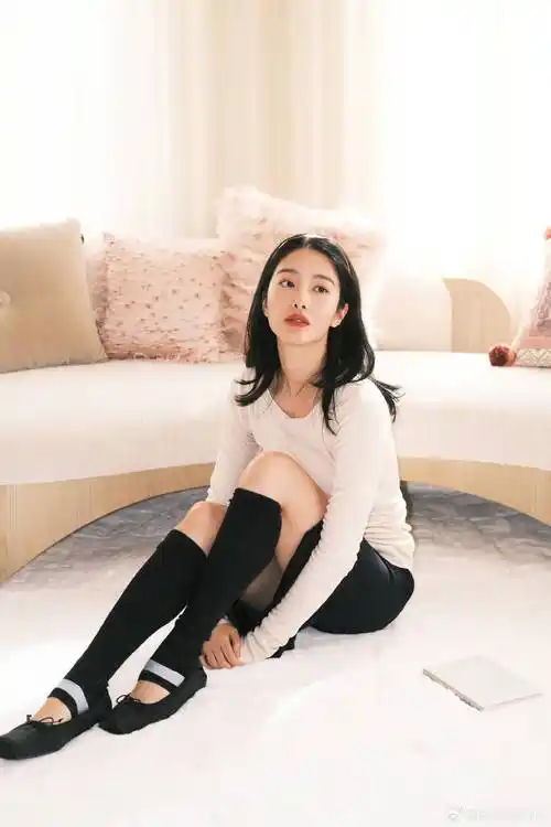 而穿上黑色短裙的杨采钰,单手托着俏脸,坐在沙发上翘起自己的大长腿