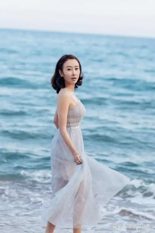 提着裙摆在海风与波浪中嬉戏的毛俊杰,一脸幸福的模样.