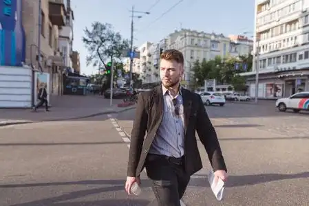 马路红绿灯一个穿着服装的漂亮男人在行人过路处穿过马路的画像.