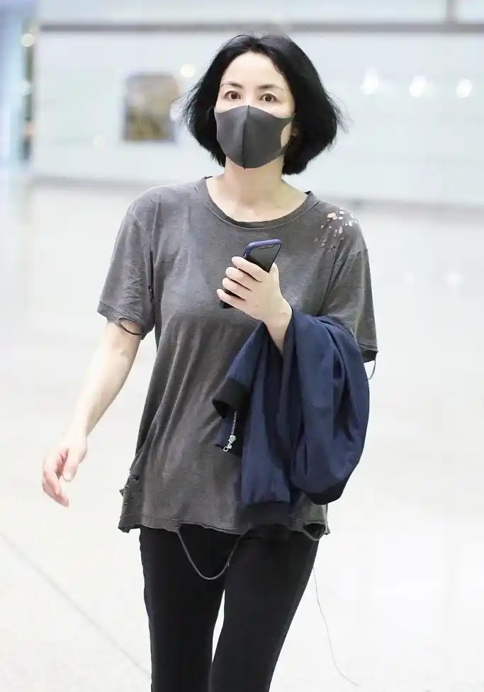 10月23日,王菲素颜现身北京机场,当日她戴着口罩难掩皮肤白嫩,身穿破