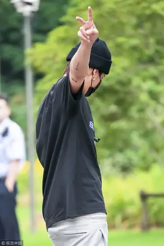 吴亦凡现身机场又酷又潮 对镜比"小心心"