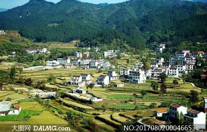 山脚下美丽的村落全景摄影图片