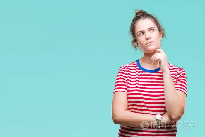 黑发卷发年轻女孩穿着随意的目光越过孤立的背景,手在下巴上思考问题