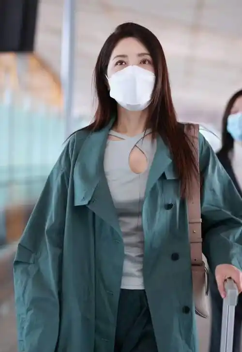 曾黎的这套春季机场私服,用沼泽绿中长款休闲风衣搭配裤裙,休闲时尚与