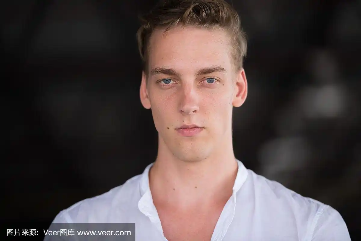 户外年轻英俊的卷发男子的大头照