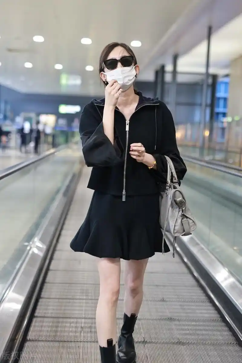 古力娜扎机场随拍,黑色连帽外套搭配半身短裙,切尔西靴甜酷可爱!
