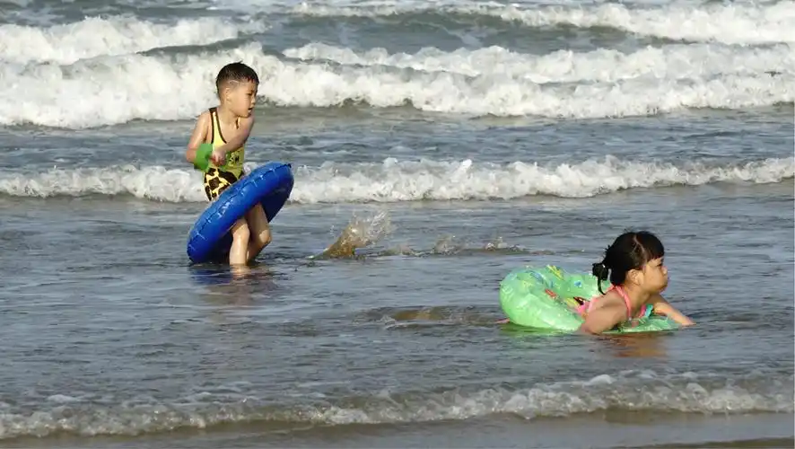 小朋友一起在海边游泳戏水