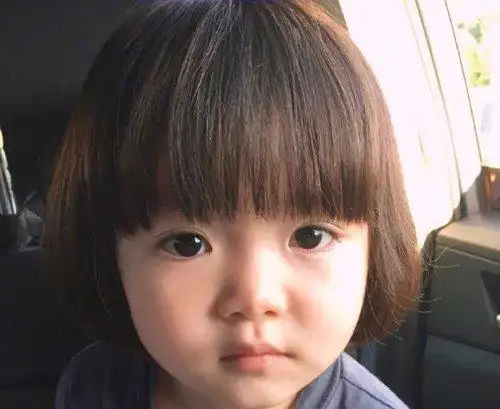 了一边一个小发夹,把头发梳成中分两部分的效果,女童梳短发妹妹头发型