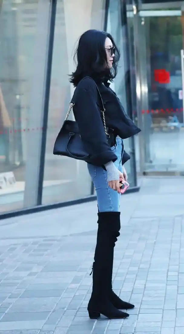 过膝靴与牛仔裤搭配腿部的线条给人一种很有气质的感觉