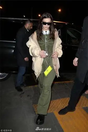 贝拉哈迪德外套半脱边走边撩发秀冰山脸架黑超戴耳机潮范十足