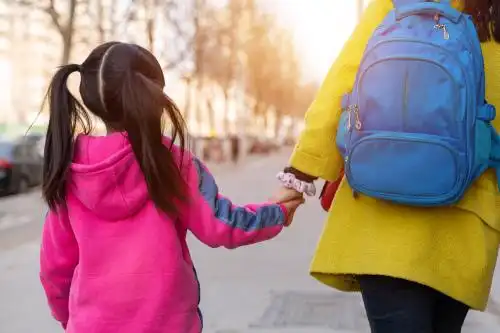 放学后小学生和妈妈手拉手的背影