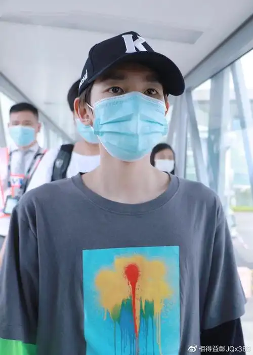 是王源现身某机场的路透照,照片中的王源黑衣黑帽戴口罩装扮严实,这大