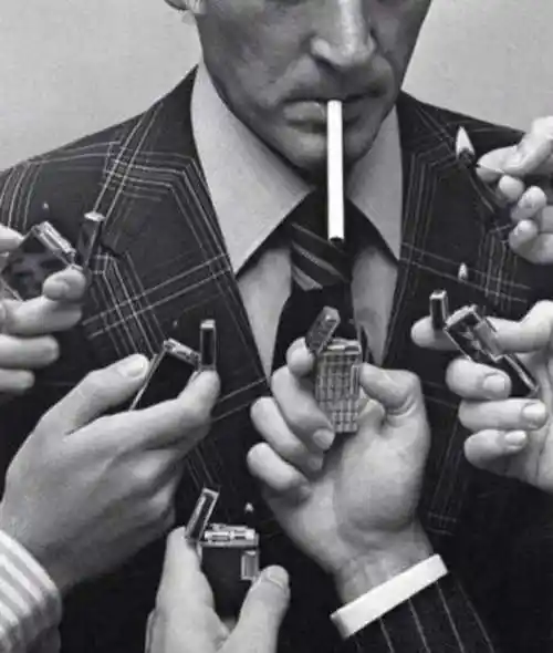 一个男老外叼着一根烟下面有很多个打火机给他点烟的图片求原图