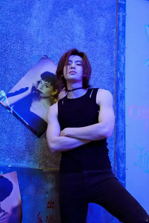 王琳凯身着黑色紧身背心的小鬼在街角霓虹灯小店的背景中摆pose__财经