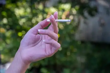 一只手拿着阴燃的香烟图片